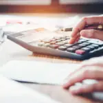 Businessman's hands with calculator and cost at the office